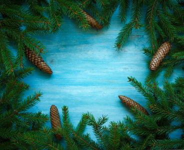 圣诞树枝与锥上准备好的蓝色木纹理