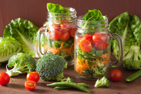 健康的蔬菜沙拉，梅森罐子里。番茄西兰花胡萝卜豌豆