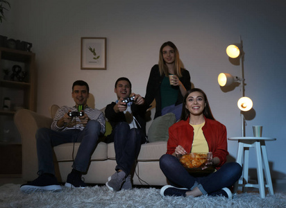 晚上在家玩电子游戏的年轻人照片