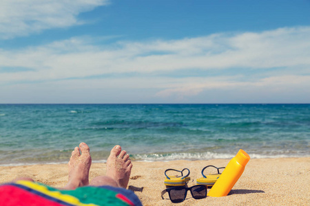 沙滩上的人在日光浴.脚和触发器的浅景深照片