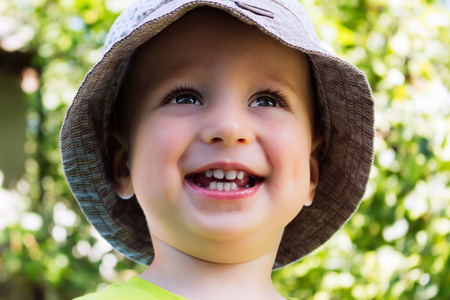 在 f 的夏天帽子微笑美丽的孩子的肖像