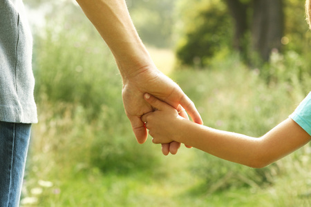 手牵着快乐的父母和孩子负责任的人在花园里花时间父母夫妇与女儿和