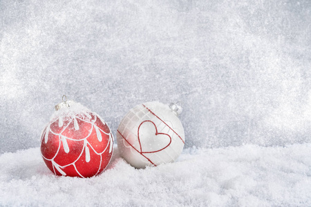 雪中的红色和白色的圣诞球。圣诞背景。复制空间。新年背景