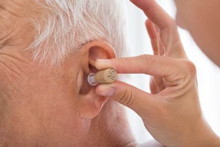 医生在病人的耳朵把助听器