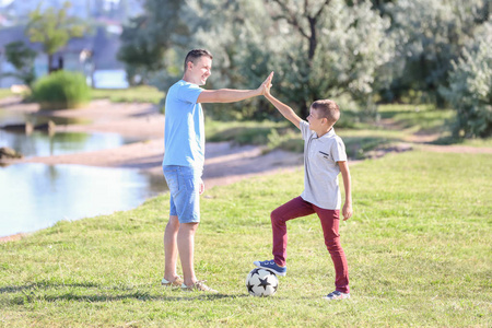小男孩和他的父亲用足球给高五室外