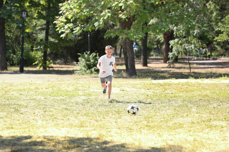 小男孩在户外踢足球