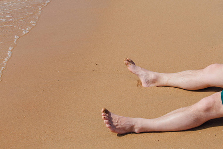 在海滩上的人的裸脚。砂纹理