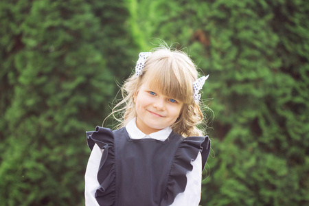 一个小开朗的蓝眼睛女孩的肖像一级与 bantikami 和眼镜在学校制服与公文包在9月1日