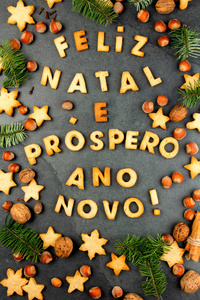 洛费里兹出生的曲奇饼。圣诞快乐, 新年愉快, 葡萄牙语与烘焙饼干, 圣诞装饰和坚果在黑色石板背景。葡萄牙语国家的圣诞贺卡顶级视图