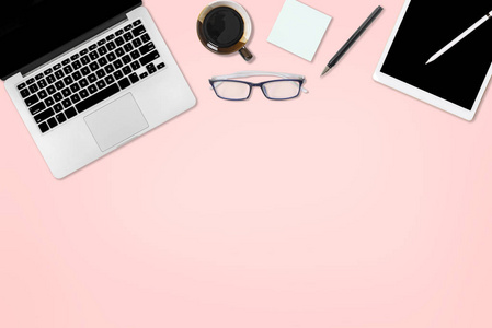 平躺照片的办公桌上有笔记本电脑, 数码片, 手机和配件。在独立的粉红色背景上。台式机办公室样机概念