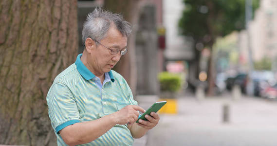 亚洲老人在户外使用手机照片