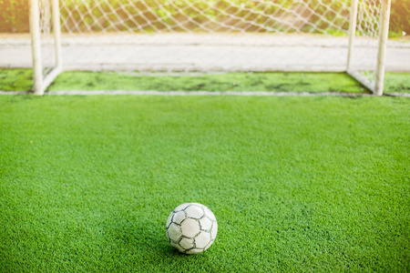 足球在人造草皮和在目标前面。它是为绿色背景和情况的概念