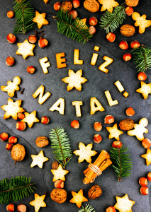 洛费里兹出生的曲奇饼。圣诞快乐, 与烤饼干, 圣诞装饰和坚果在黑色石板背景的葡萄牙语。葡萄牙语国家的圣诞贺卡顶级视图