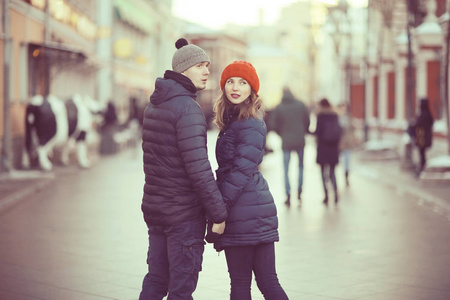 年轻的男人和女人走在冬天的城市, 浪漫的幸福夫妇