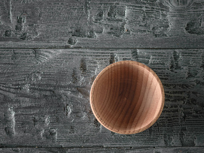 木碗在黑暗的木桌上。木制器皿的物品。从顶部的视图。平躺