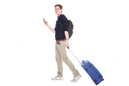 在孤立的白色背景下, 带着手提箱和手机的年轻人的全身侧面肖像照片