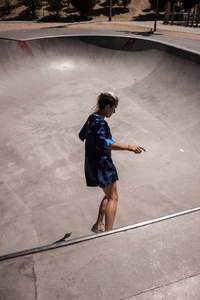 都市风格的年轻妇女做滑板在 skatepark