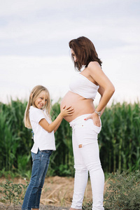 小女孩与她怀孕的母亲在领域