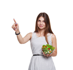 微笑的女人拿着新鲜蔬菜沙拉，触摸想象中的SCR。