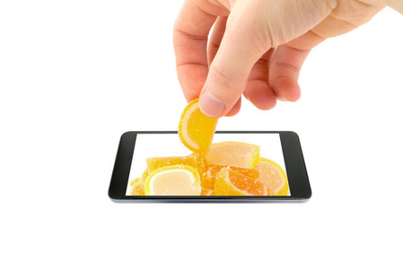 一只手的概念创意3d 立体照片, 在玻璃罐子里, 用五颜六色的糖果在釉上, 在白色背景下的智能手机屏幕之外。