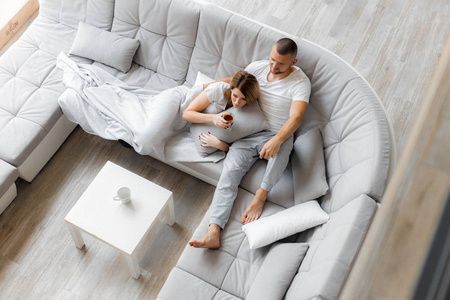 婚姻生活年轻夫妇在家里的沙发上休息.家庭休闲生活方式照片