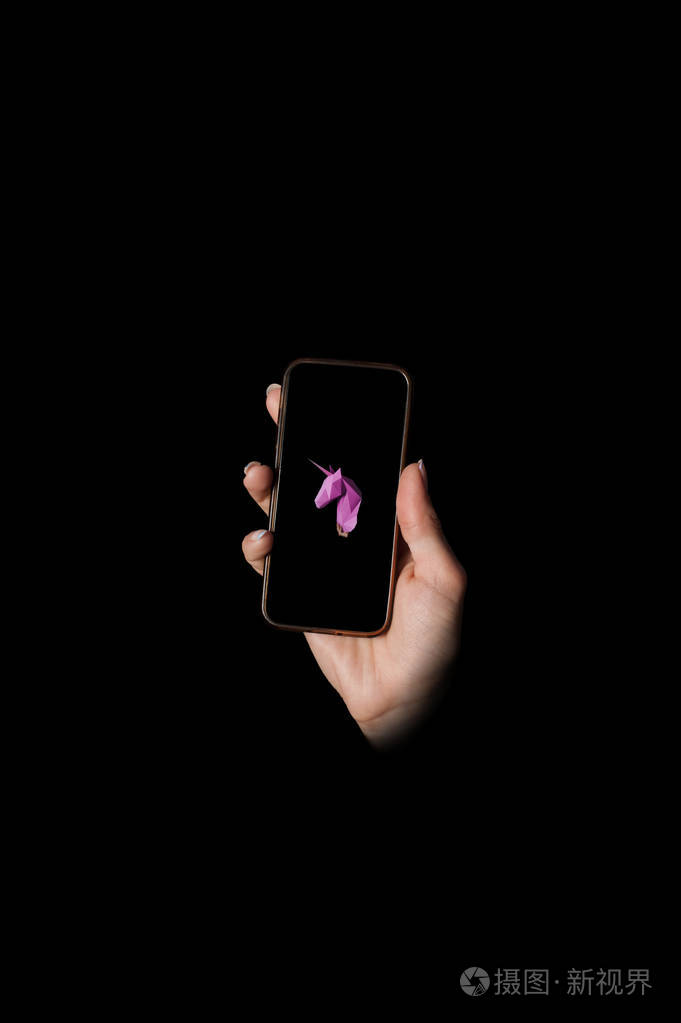 人的手拿着电话, 屏幕上显示了粉红色的独角兽
