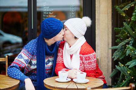 幸福夫妇喝咖啡在巴黎户外咖啡馆装饰圣诞节