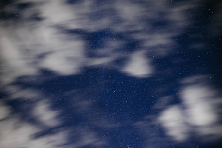 深蓝色夜空的背景, 无数闪烁的星星和移动的白云后, 它