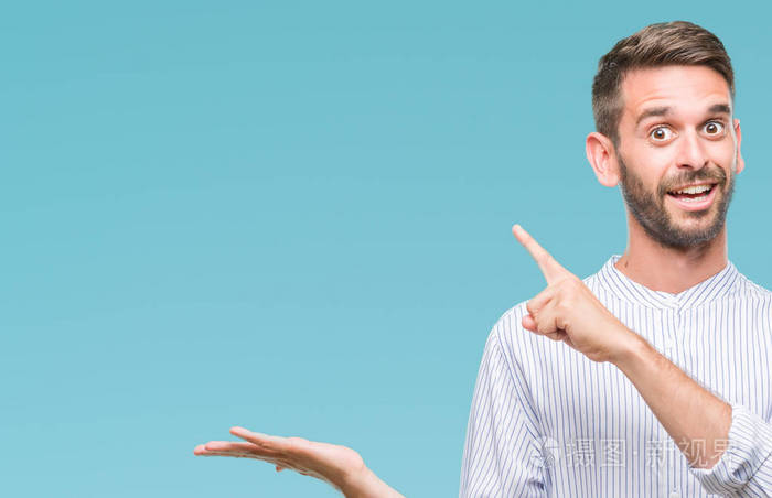 年轻英俊的人在孤立的背景下惊讶和微笑的相机, 而提出用手和手指指着