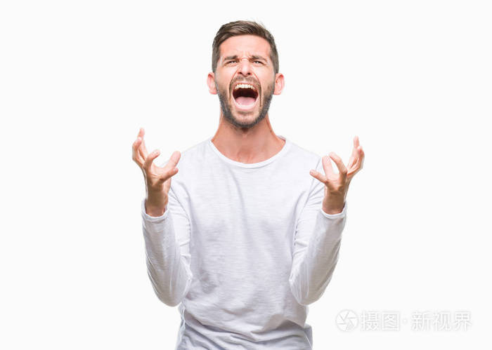 年轻英俊的男人在孤立的背景下疯狂和疯狂的呼喊和激烈的表达和手臂