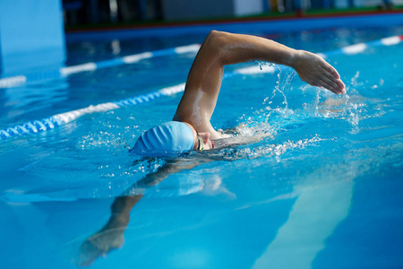 蓝帽运动男子在泳池游泳的形象