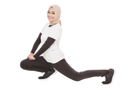 穆斯林的运动型女人做腿部拉伸