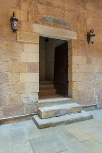 古外旧装饰砖石墙和门口通向埃及建筑历史建筑的房子, 开罗, 埃及