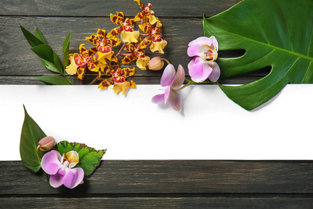 在木背景的新鲜的热带叶子, 花朵和空白纸的组成