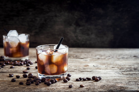 自制酒精醉醺醺黑俄罗斯饮料与咖啡豆在木质背景与拷贝空间照片