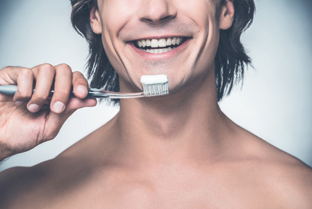 男人刷牙，微笑