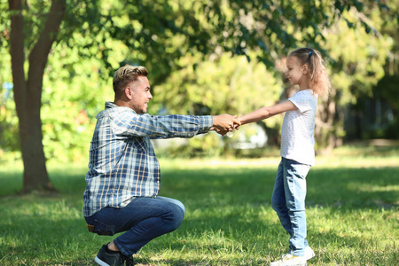 快乐的父亲和女儿在绿色公园