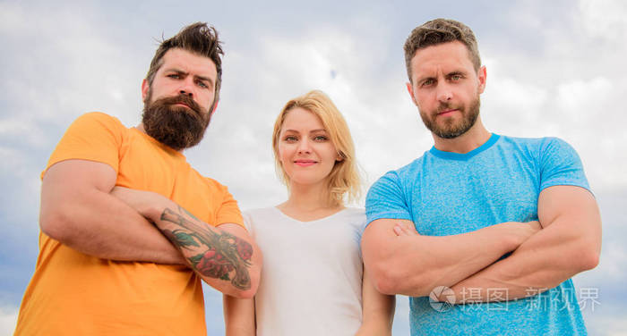 三人自信地站在双臂上.凝聚力团队的行为.三个看着你