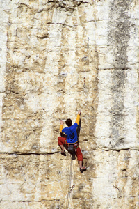 Cliffhanger.Young 男登山者悬挂在悬崖上