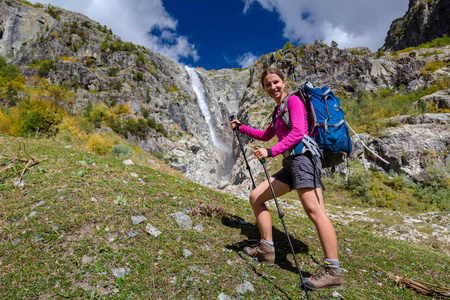 女人对高 waterfal 中我们在高加索山脉徒步旅行