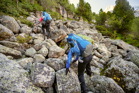 徒步旅行者都爬在阿尔泰山的岩质边坡