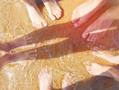 家庭的脚，在海滩上的沙