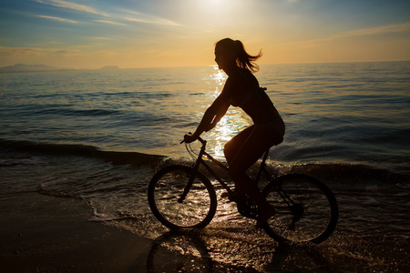自行车运动在海滩度假的女人