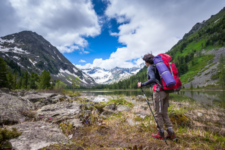 女人在湖在阿尔泰山的小路上徒步旅行