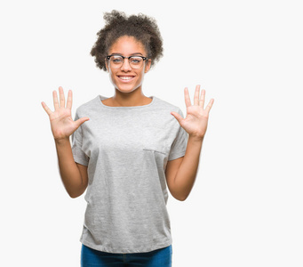 年轻的美国黑人妇女戴着眼镜在孤立的背景显示和指向十的手指, 而微笑着自信和快乐