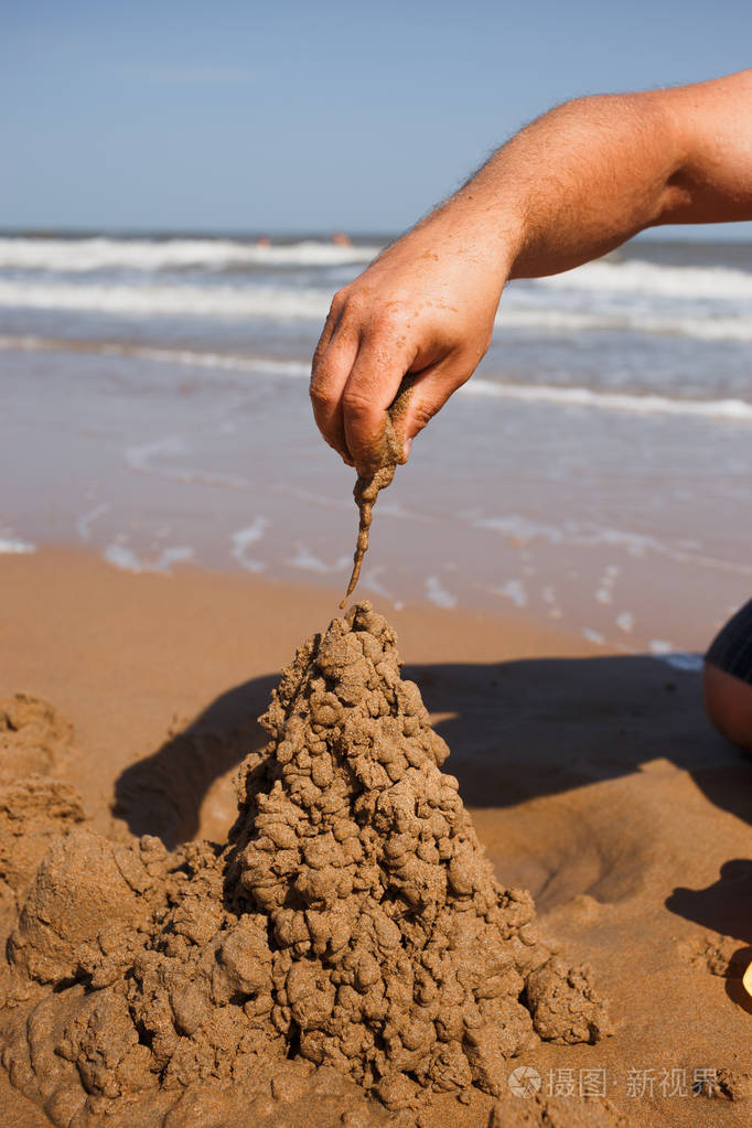 关闭人的与建筑沙子城堡在海滩