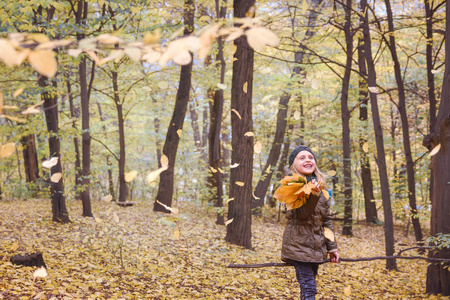 秋天森林。秋天的心情。带着一束秋叶的小女孩