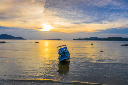 在泰国普吉岛拉威海滩日出。拉威海的渔船, 多云的天空