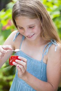 小女孩吃一片西红柿