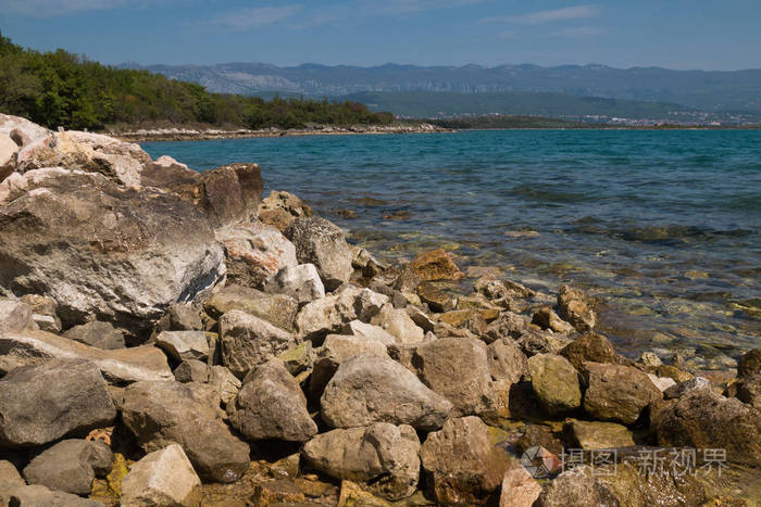 在亚得里亚海的清澈清澈的海水中, 海岸上的大石头.